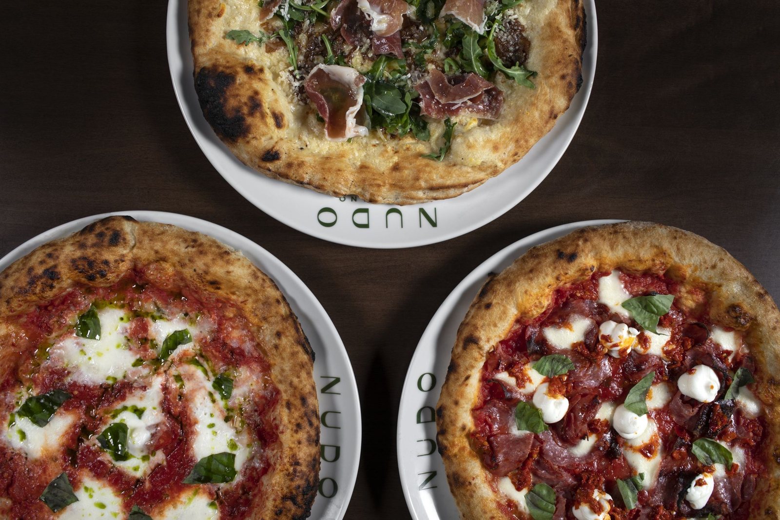 Three pizzas fresh from the wood-burning oven